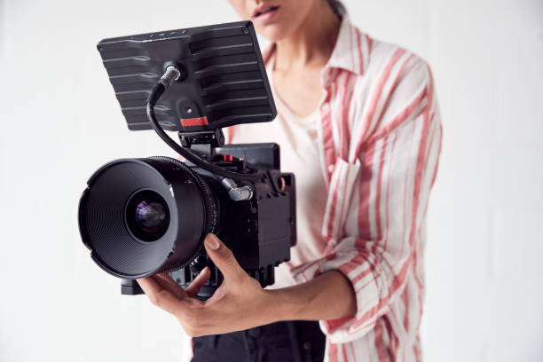 istock Female Videographer With Video Camera Filming Movie In White Studio 1170667916