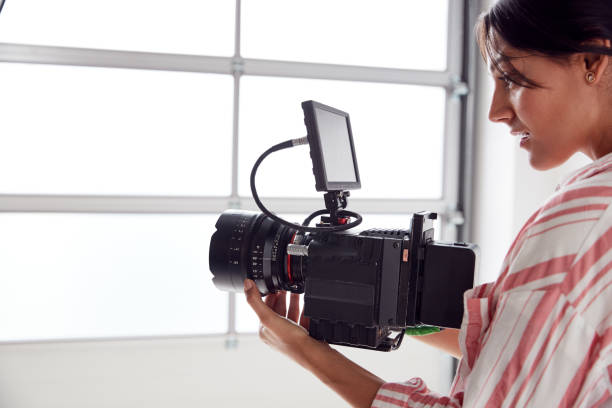 istock Female Videographer With Video Camera Filming Movie In White Studio 1170668054