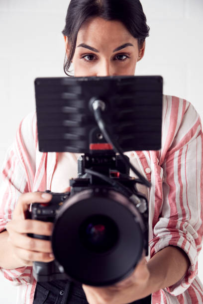 istock Female Videographer With Video Camera Filming Movie In White Studio 1170668068
