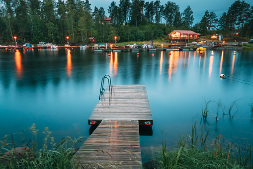 Sweden. Beautiful Wooden Pier Near Lake In Summer Evening Night. Lake Or River Landscape. Riverside