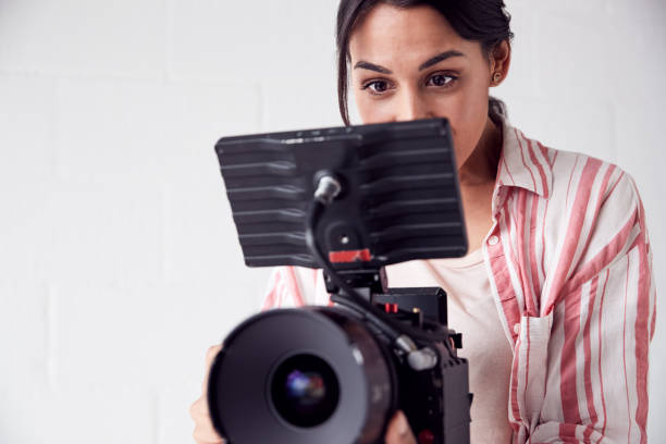 istock Female Videographer With Video Camera Filming Movie In White Studio 1170669896