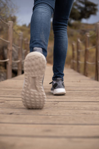 istock Runner feet running on wood bridge closeup on shoe. Selective focus 1170671036