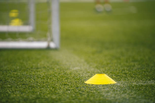 istock Soccer training equipment on green artificial turf with training background. Football training equipment: soccer goal, net and cones 1170671205