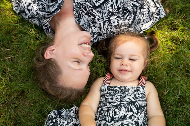 istock happy mom and daughter laying on grass 1170672193