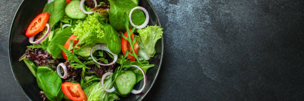 istock healthy salad (tomato, cucumber, mix leaves, onions and other ingredients) top menu concept. food background. copy space 1170675370