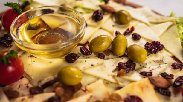 Feta cheese cubes with spices and olives in oil marinade. Close up, macro photo.