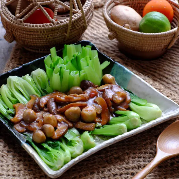 Top view simple meal for vegans, fresh green bok choy sauce with mushrooms, healthy food from vegetables, a vegetarian dish that good for health, delicious and nutrition