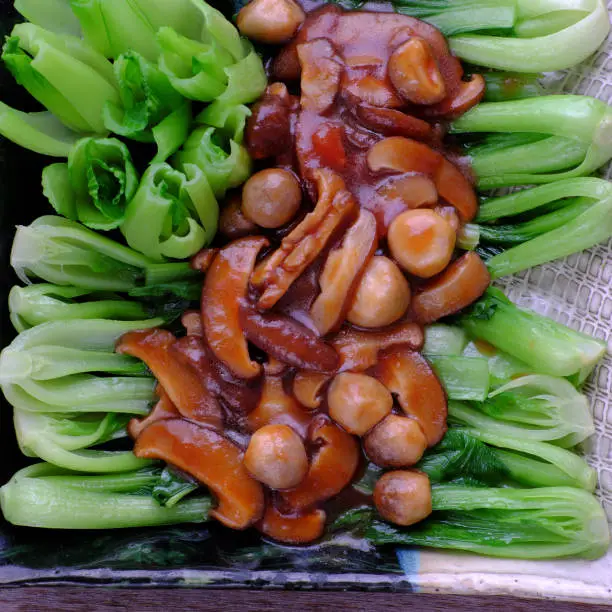 Top view simple meal for vegans, fresh green bok choy sauce with mushrooms, healthy food from vegetables, a vegetarian dish that good for health, delicious and nutrition