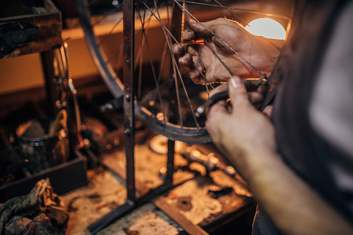 One man, repairing a bicycle in his work shop, part of.