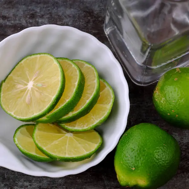 Top view lemons and lime slices for detox water on gray wooden background, a drinking water for healthy diet and skin care
