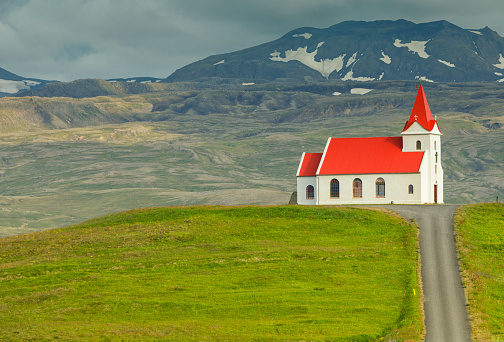 Blue wooden Church at Seydisfjordur, Iceland, view from the side with snow mountains in the background