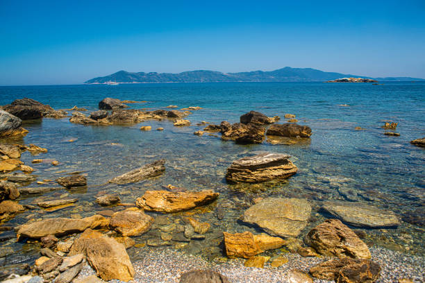 Crystal clear sea and the picturesque pebbled beach in Skiathos, Greece