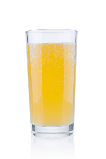 Glass of orange juice on yellow and orange background