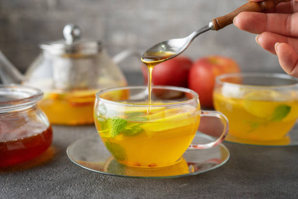 istock Pouring a honey into glass cup of fruit tea 1170687486