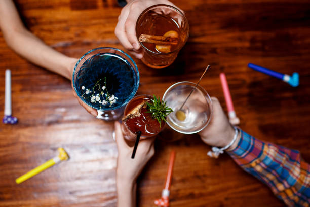 istock friends clinking by glasses with various alcoholic cocktails at table 1170688418