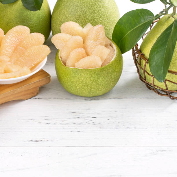 istock Fresh peeled pomelo, grapefruit, shaddock with green leaf on bright wooden plank table. Seasonal fruit near mid-autumn festival. 1170696984