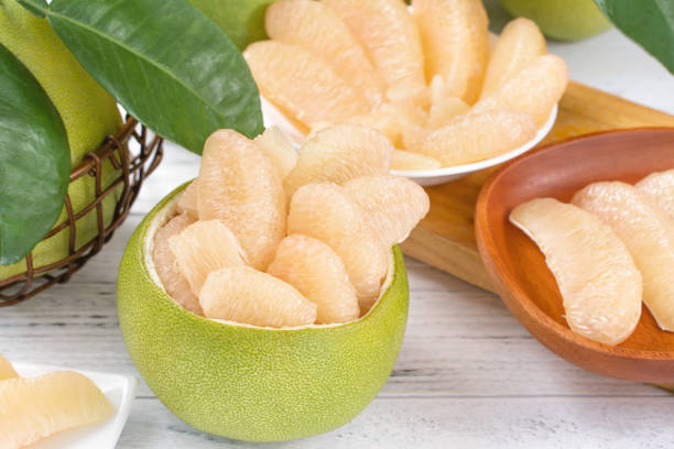 istock Fresh peeled pomelo, grapefruit, shaddock with green leaf on bright wooden plank table. Seasonal fruit near mid-autumn festival. 1170697005