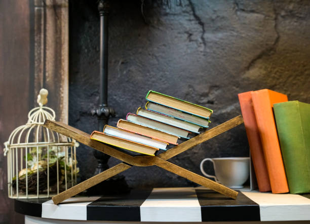 istock Stacked books resting on wood stand 1170698227