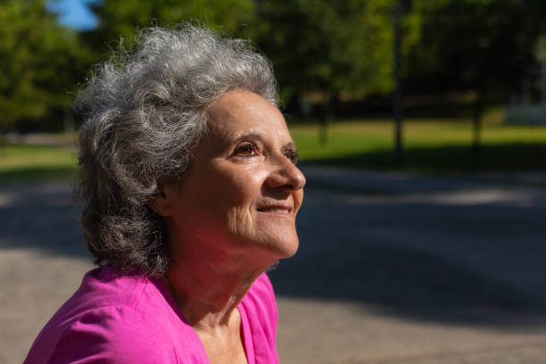 istock Happy peaceful old lady enjoying walk in park 1170698262