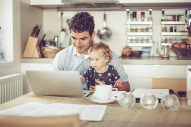 fahter montre des choses à sa fille sur un ordinateur portable - two parent family indoors home interior domestic kitchen photos et images de collection