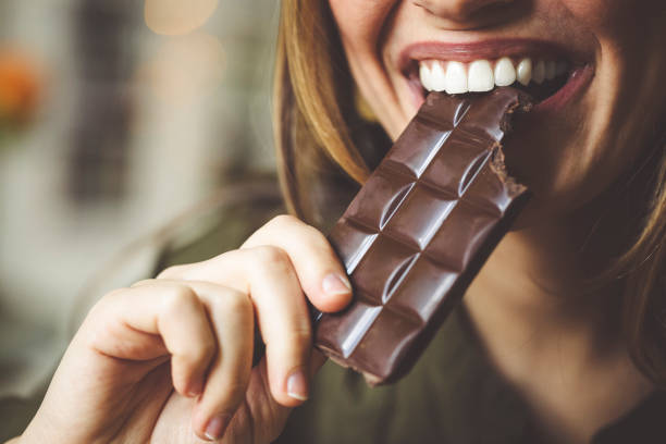 comer chocolate - human mouth human teeth indoors young women fotografías e imágenes de stock