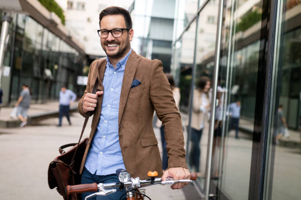 istock Happy young stylish businessman going to work by bike 1170699033
