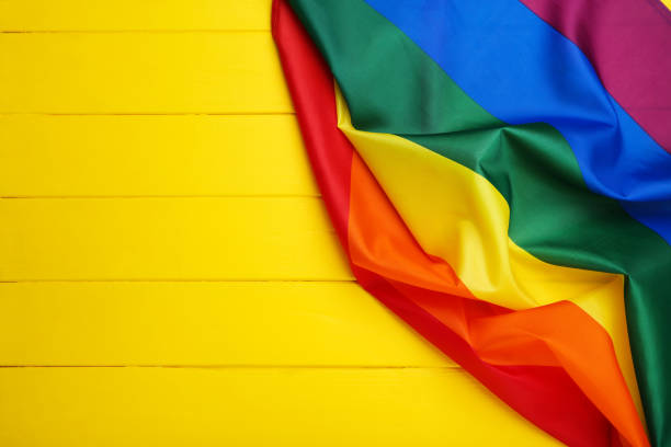 istock Rainbow flag on yellow wooden table 1170699046