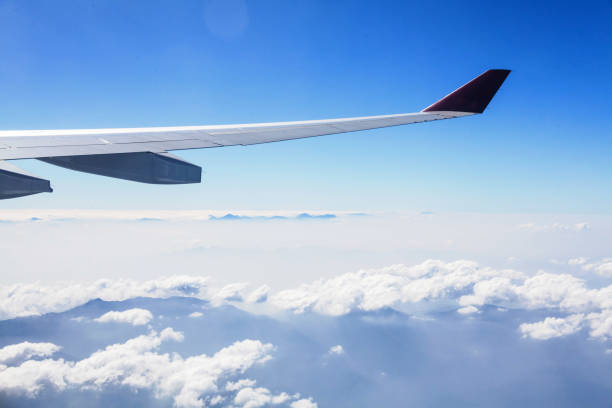istock Plane wing view from inside plane in midair with blue sky cloud background 1170700723