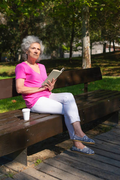 istock Disturbed old lady with book staring away 1170703887