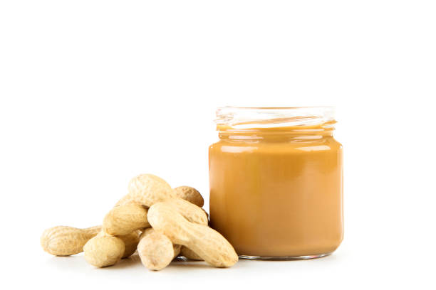 istock Peanut butter in glass jar with nuts isolated on white background 1170705289