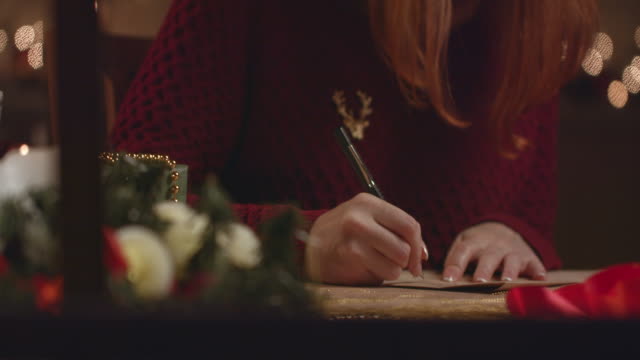 Beautiful girl writes a letter to Santa Claus.