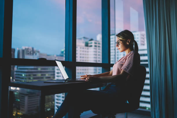 istock Young attractive skilled marketing expert in eyeglasses watching training webinar in webpage on laptop connected to 4G internet.Pretty hipster girl transferring money online via banking service 1170706666