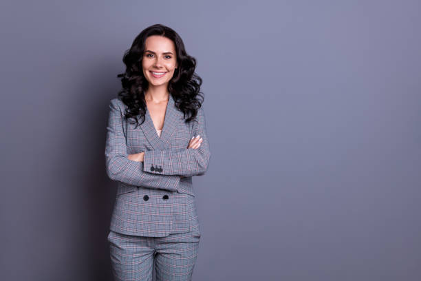 verticale de belle femme croisant ses mains utilisant le pantalon de pantalon d'isolement au-dessus du fond gris - blazer photos et images de collection