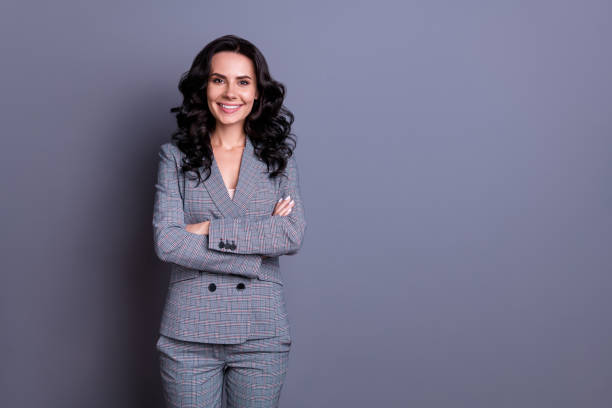 Portrait of beautiful woman crossing her hands wearing pants trousers isolated over gray background Portrait of beautiful woman crossing her hands wearing pants trousers, isolated over gray background chief leader photos stock pictures, royalty-free photos & images