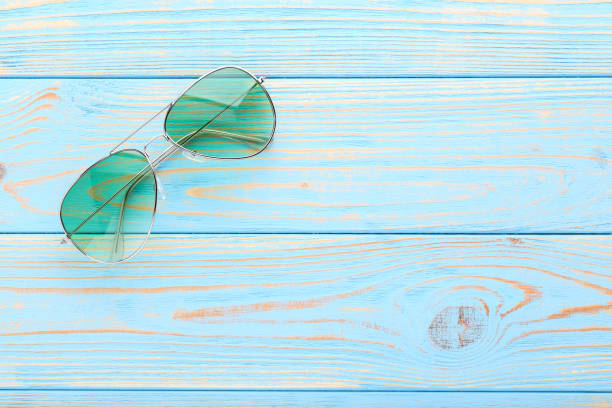 istock Modern sunglasses on blue wooden table 1170708242