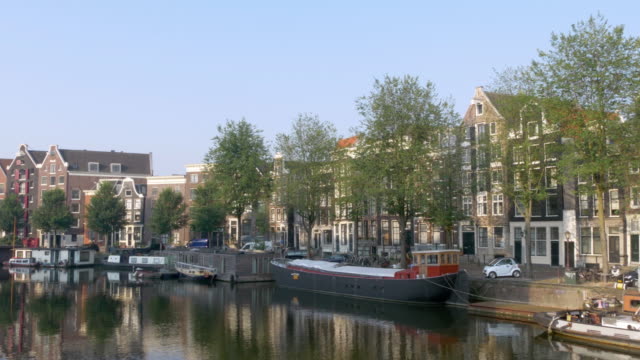 Amsterdam canal with houseboats and houses
