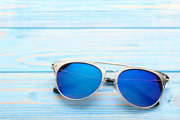 istock Modern sunglasses on blue wooden table 1170709118