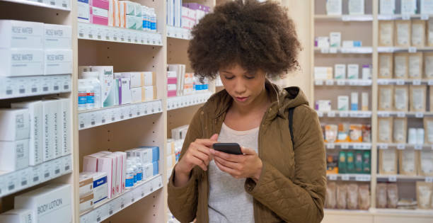 istock Woman using smartphone in pharmacy 1170709356
