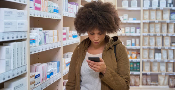 istock Woman using smartphone in pharmacy 1170709377