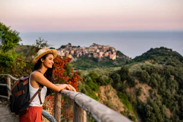 Female tourist enjoying beautiful view to Corniglia village at Cinque Terre, Italy