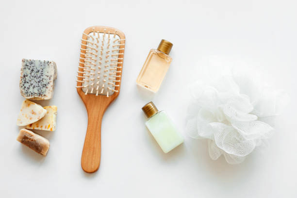 Flat lay bath products, cosmetic for shower. Shampoo or shower gel, soap bar, cotton towel, wooden comb and seashells. Top view photo natural cosmetics stock photo