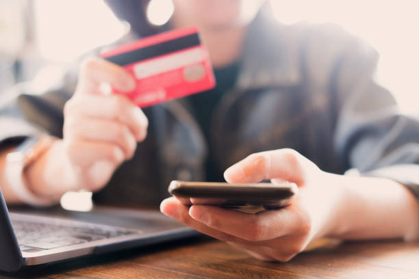 istock online payment,Young woman's hands using computer and hand holding credit card for online shopping. 1170715746
