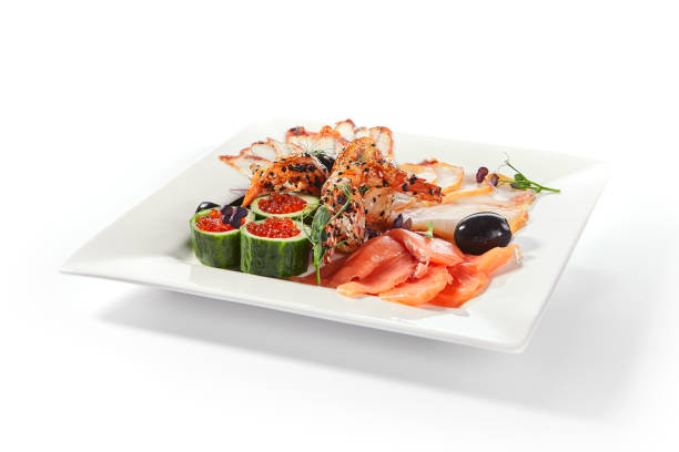 Fish platter with pink salmon, grilled eel, oil fish balyk and red caviar on elegant restaurant plate isolated on white background. Exquisite serving thin slices of salted and dried delicious seafood