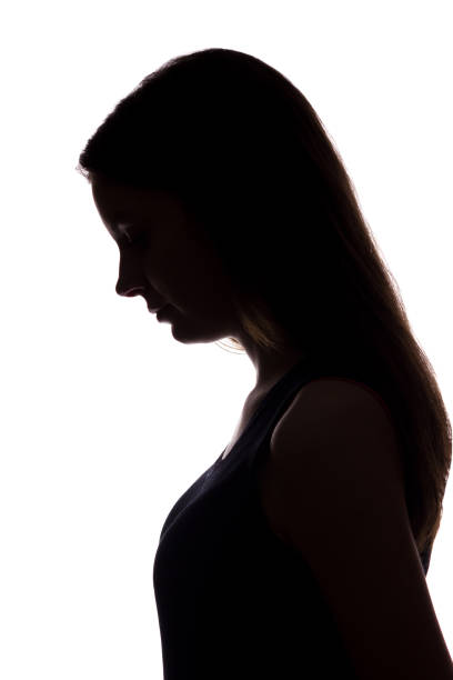 istock Young woman look down with flowing hair - vertical silhouette 1170717156