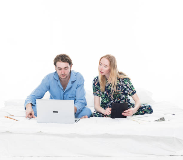istock Two people sitting up in bed working 1170718713
