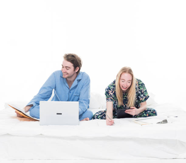 istock Two people sitting up in bed working 1170718717