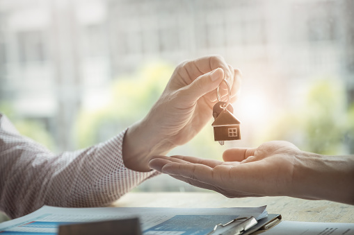 Los agentes de bienes raíces aceptan comprar una casa y dar las llaves a los clientes en las oficinas de su agencia. acuerdo y concepto de contrato. photo