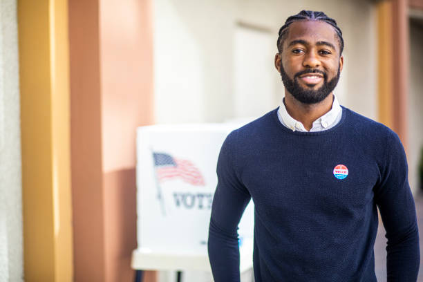 Young Black Man with I voted Sticker A young black man with his I voted sticker after voting in an election. midterm election photos stock pictures, royalty-free photos & images