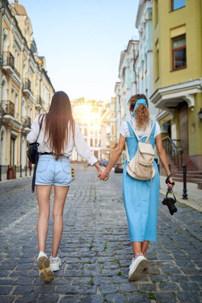 istock Girlfriends hold hands and walk around the city 1170722536