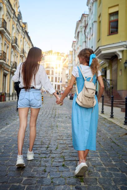 istock Girlfriends hold hands and walk around the city 1170722550